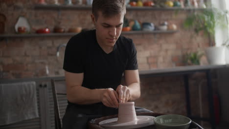 person working on pottery wheel