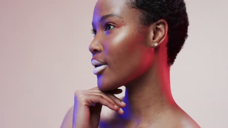 African-american-woman-with-short-dark-hair-in-blue-and-pink-light-with-copy-space,-slow-motion