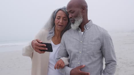 Mature-couple-enjoying-time-outside-by-the-sea