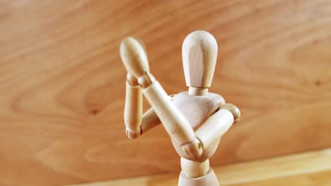 Figurine-standing-with-arms-crossed-on-a-wooden-floor