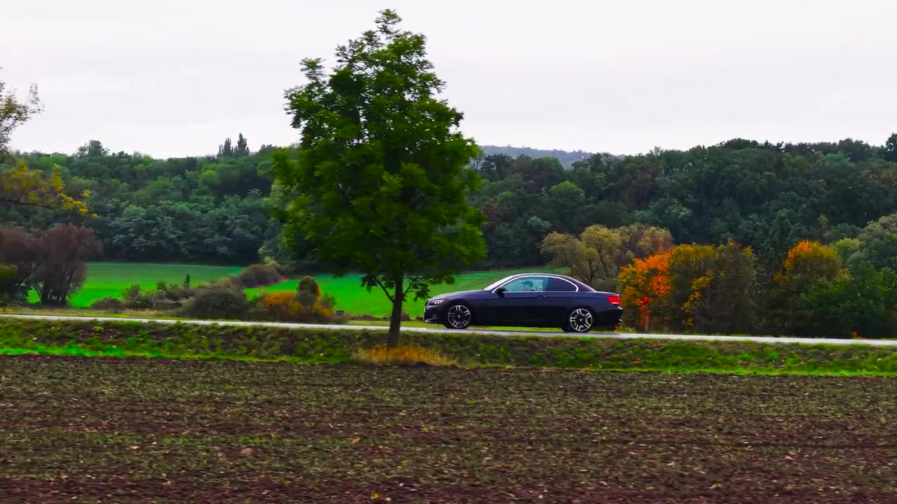Auto ripresa di lato mentre percorre una strada di campagna panoramica in autunno