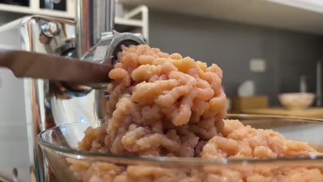 mincing chicken meat with a grinder