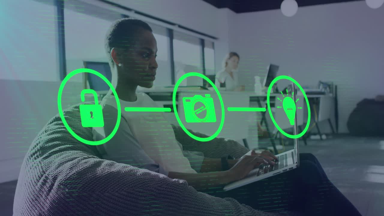 Animation of network of digital icons against african american woman using laptop at office