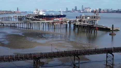 Global-crude-oil-tanker-ship-loading-at-refinery-harbour-terminal-aerial-view-right-dolly