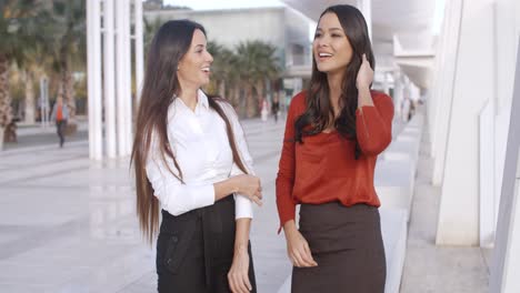 Two-chic-young-women-standing-chatting