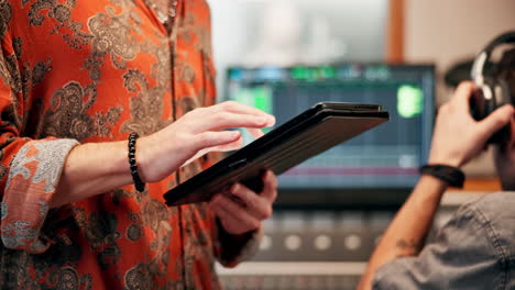 man using a tablet in a music studio