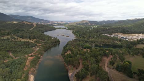 aerial over the spillway at lake eildon, victoria, australia with the goulburn river and mountains behind