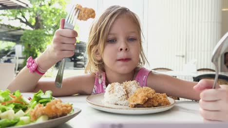 young girl eating a meal at a restaurant