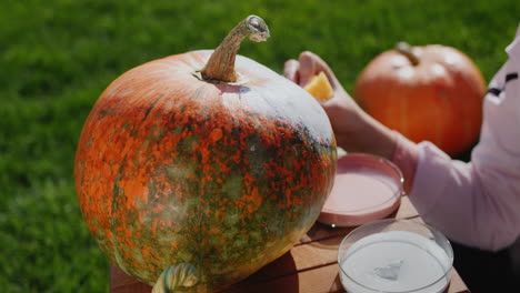 a child decorates a pumpkin - prepares festive decorations