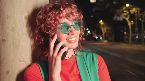 una mujer hablando por teléfono por la noche.