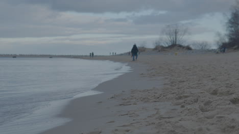 Gente-Paseando-Por-La-Playa-De-Gorki-Zachodnie-Al-Atardecer-En-Gdansk,-Polonia