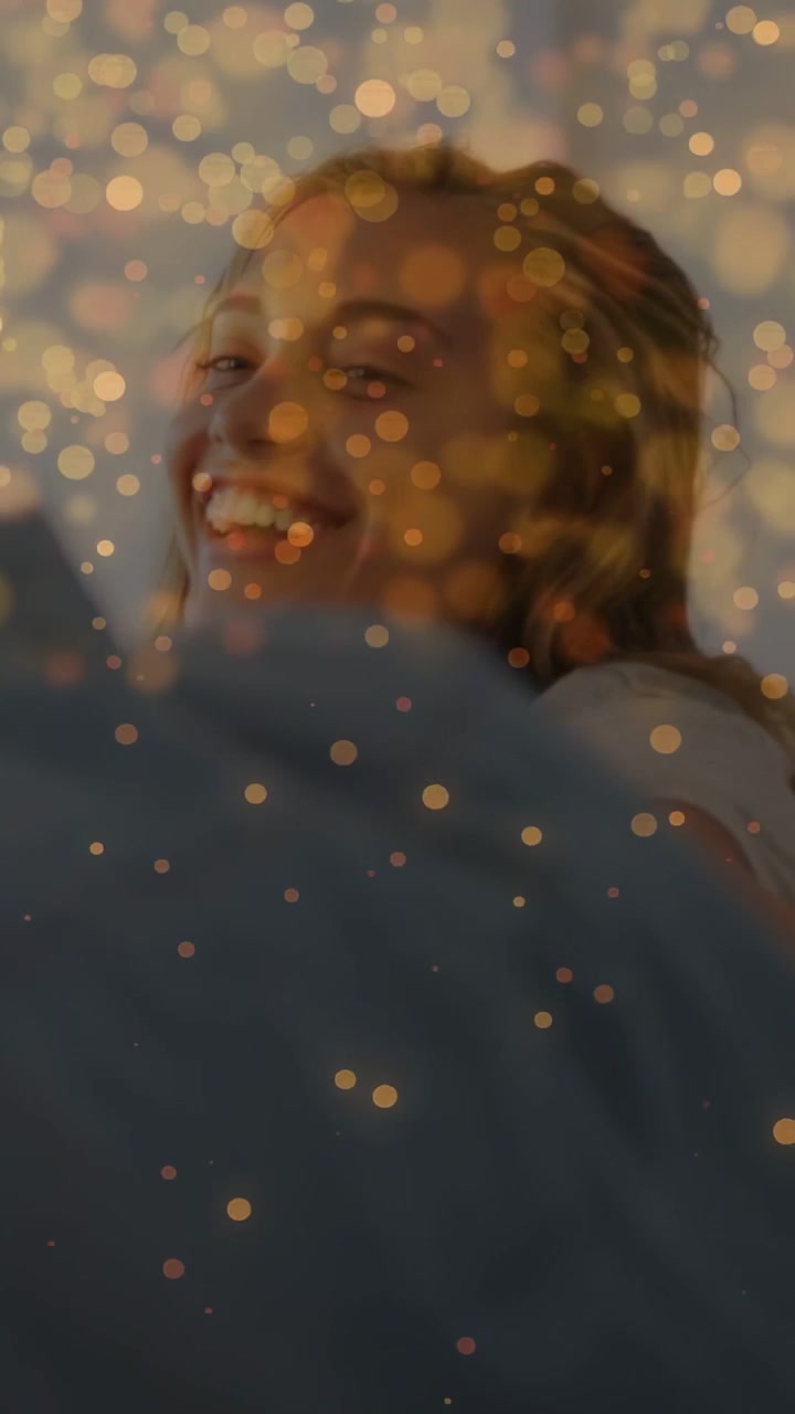 Dikey video: Mavi gömleğini düzelten adam, dönen kadın, reklamlar ve şefkat için altın bokeh altında gülümseyen.