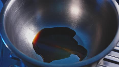 pouring soy sauce and honey into stainless mixing bowl