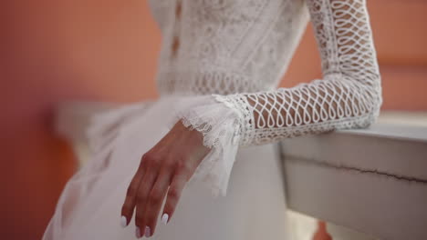 fiance in vintage wedding dress touches cracked railing