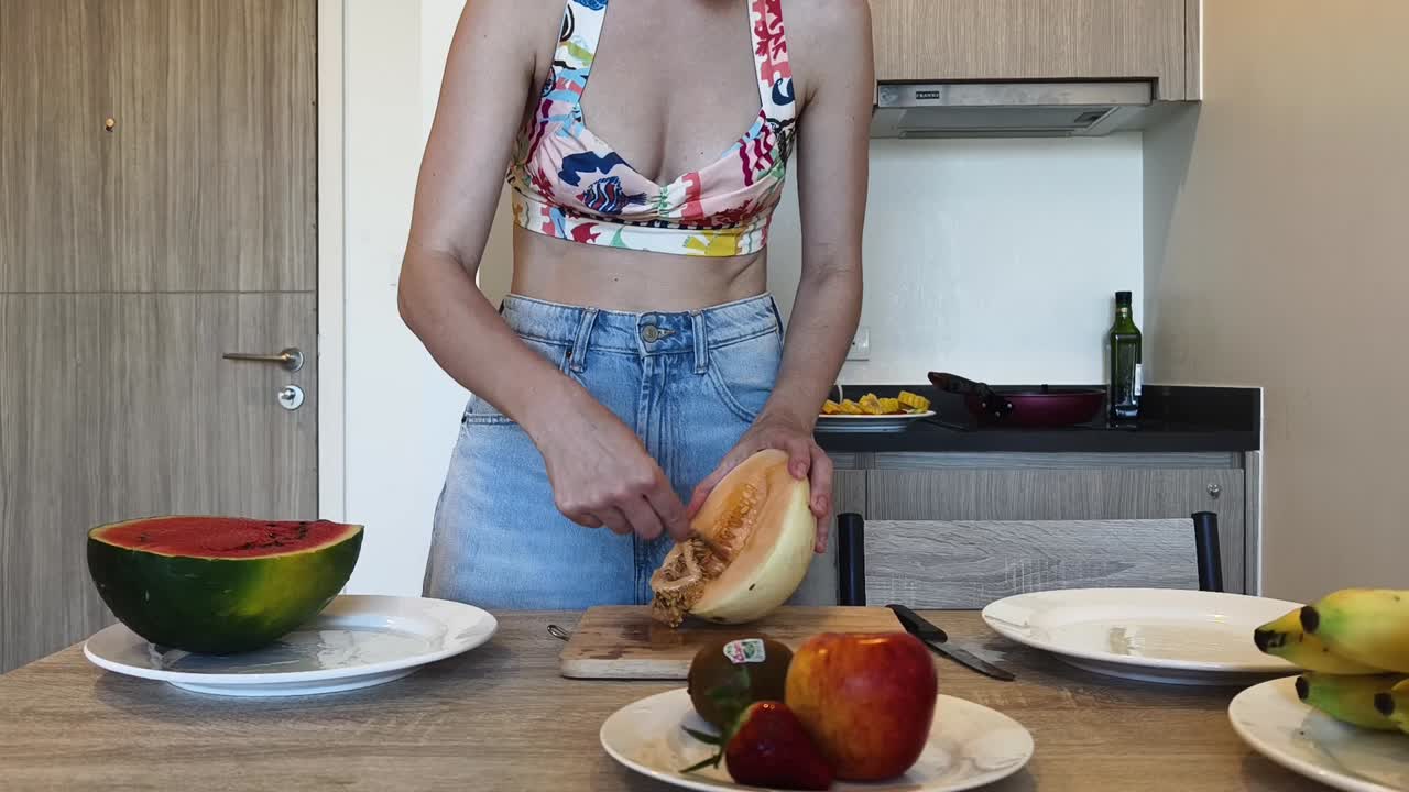 Woman cutting melon in kitchen