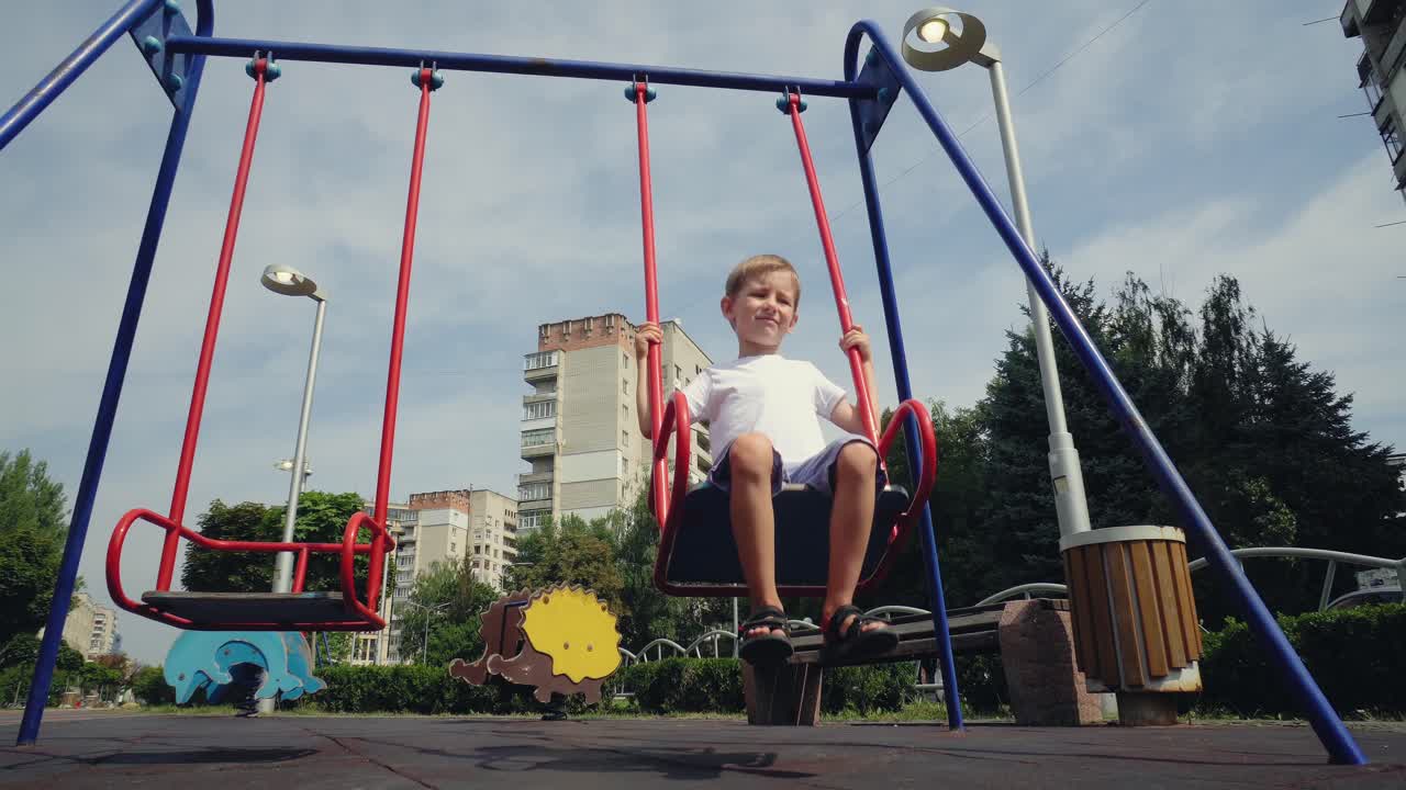 un niño se balancea en un columpio en la ciudad 01