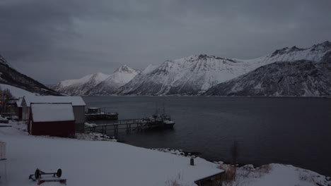 Backwards-dolly-shot-of-lake-front-apartments-at-Fjordgard,-Senja,-Norway