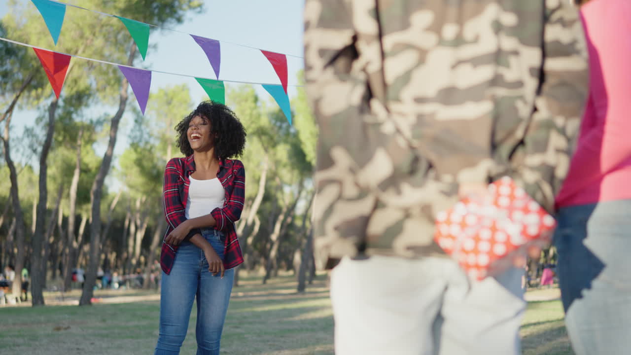 Woman laughing at outdoor party with a surprise gift