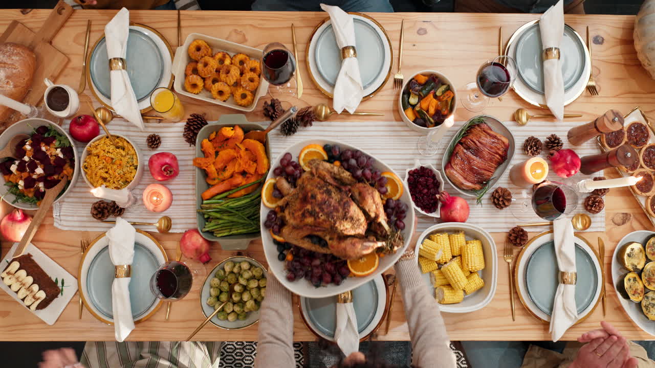 Overhead view of a Thanksgiving dinner table with family and friends celebrating the holiday