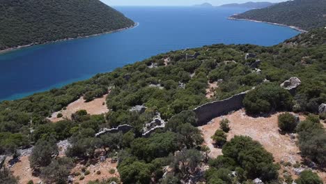 aerial orbit around broken rugged walls overlooking mediterranean sea, aperlai ancienty city of turkey