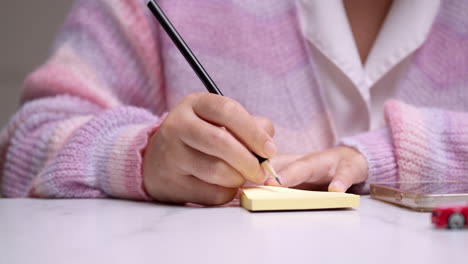 creatividad de la oficina primer plano de la mano de una mujer sosteniendo un lápiz, planeando ideas en papel amarillo