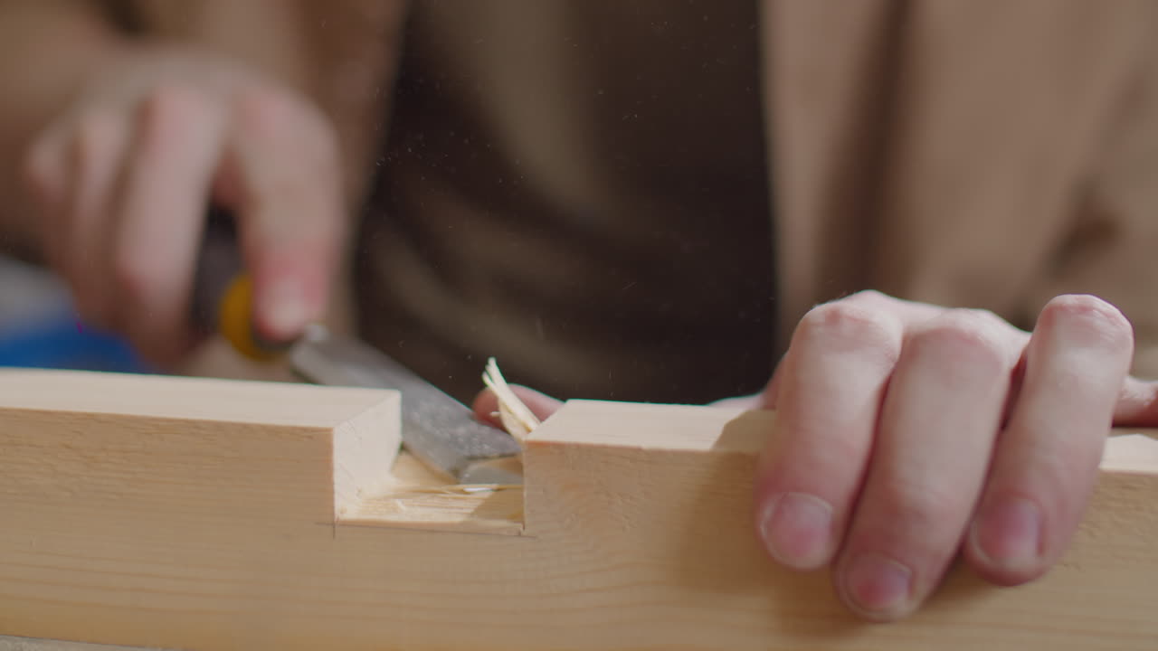 Carpenter Cutting Mortise in Wooden Plank with Chisel