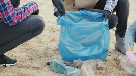 la gente pone la basura de la playa en una bolsa de recolección de basura cuidado ambiental primer plano