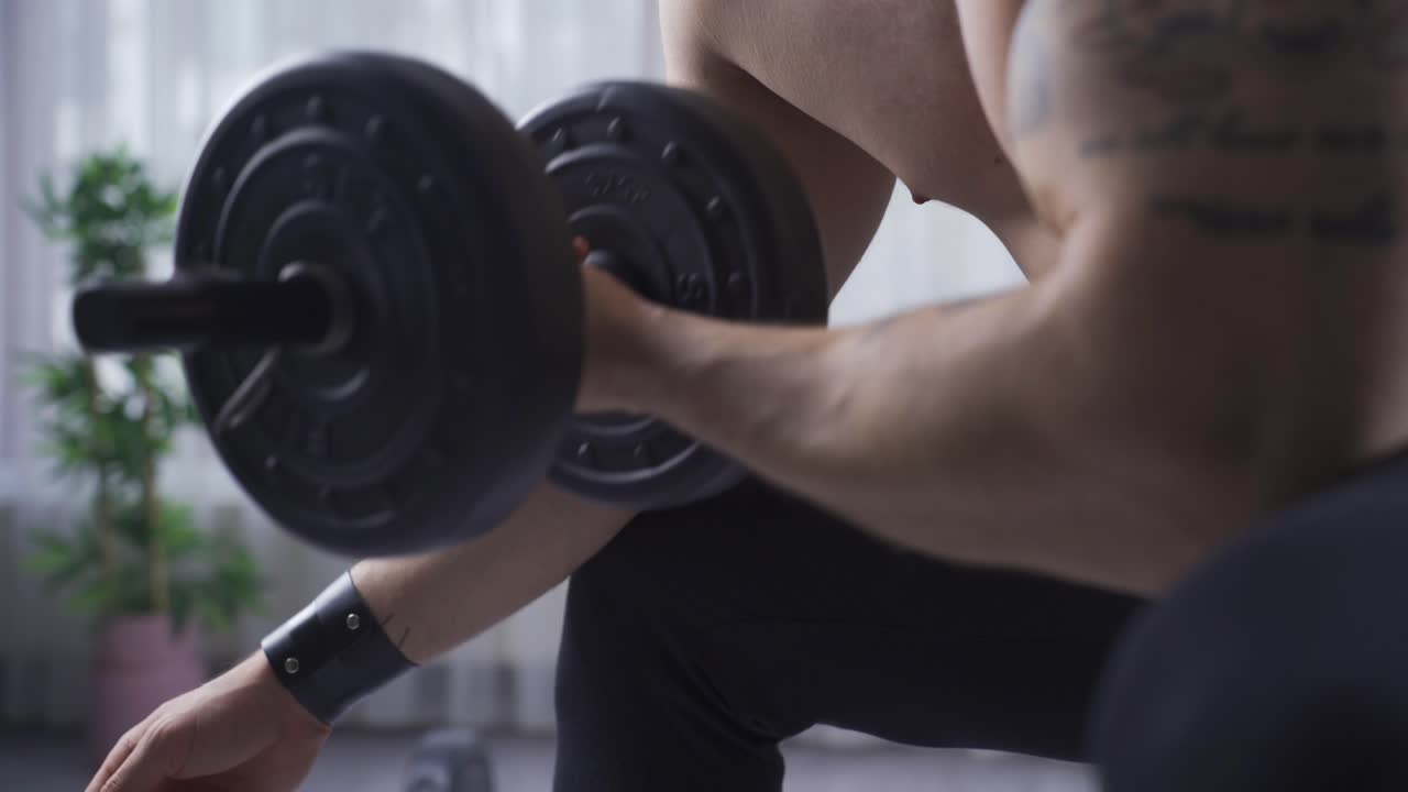 joven atleta que crece y desarrolla los músculos de sus brazos con la ayuda de pesas.