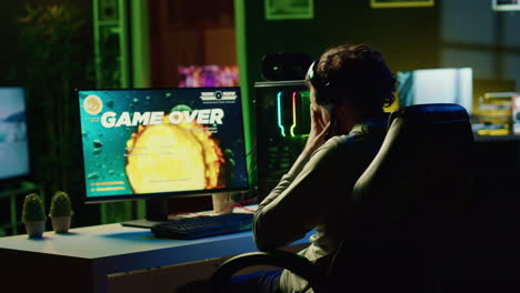 Upset-gamer-hitting-desk-in-frustration-after-receiving-game-over-screen,-getting-destroyed