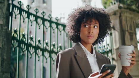 business lady talking phone with coffee cup outdoors close up. confident woman