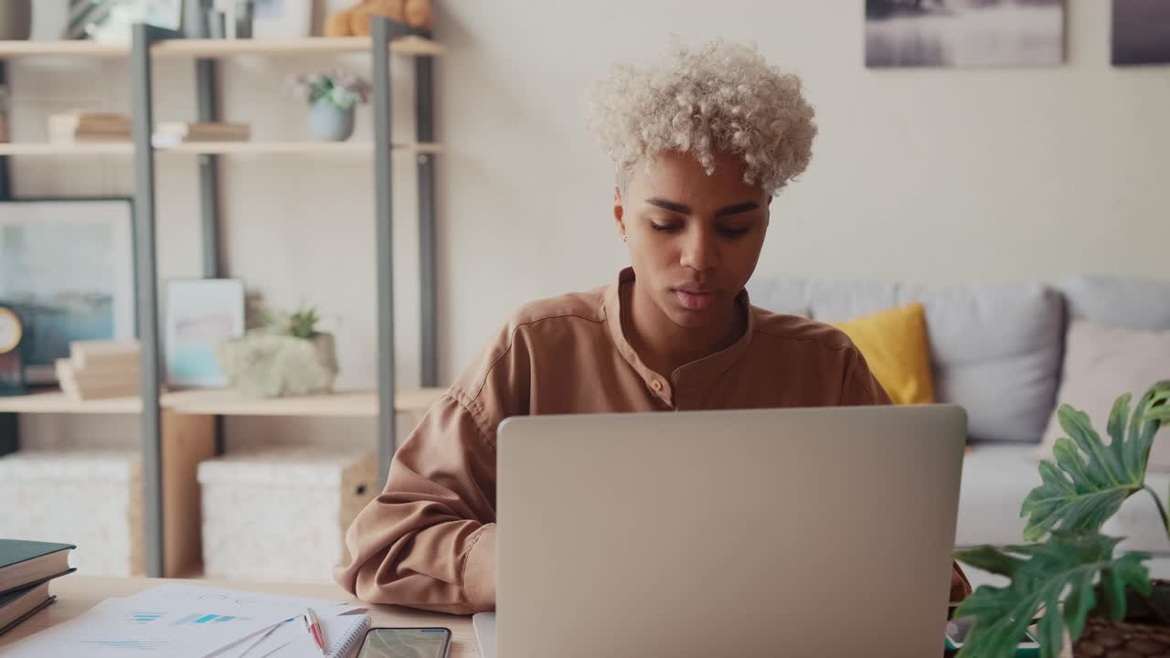 Excited african business lady is enjoying success at freelance work at home