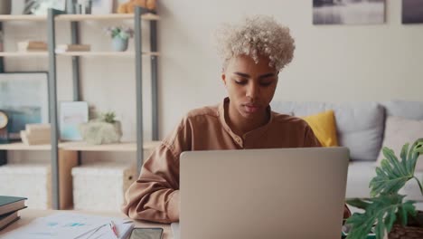 excited african business lady is enjoying success at freelance work at home