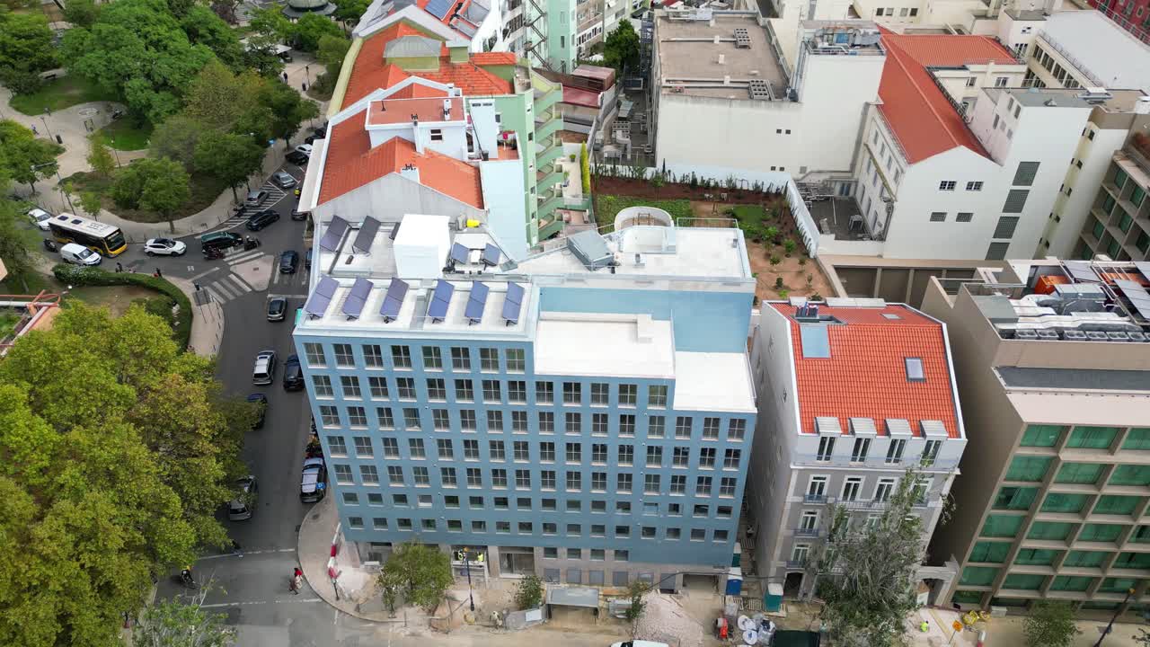 Aerial view of a new building with solar panels on the roof in Lisbon,Portugal. circular drone shot