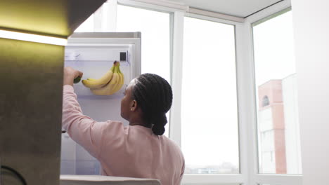 woman taking an avocado from the fridge