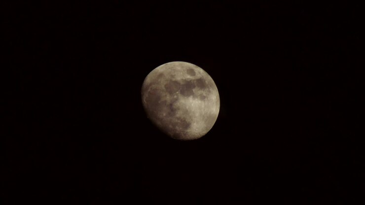 Tomada 4K da lua com nuvens passando em primeiro plano.