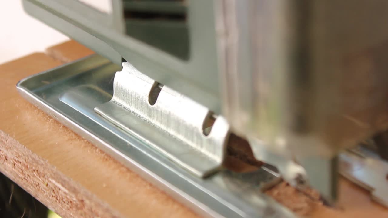 Primo piano di un seghetto alternativo che taglia il legno, con segatura