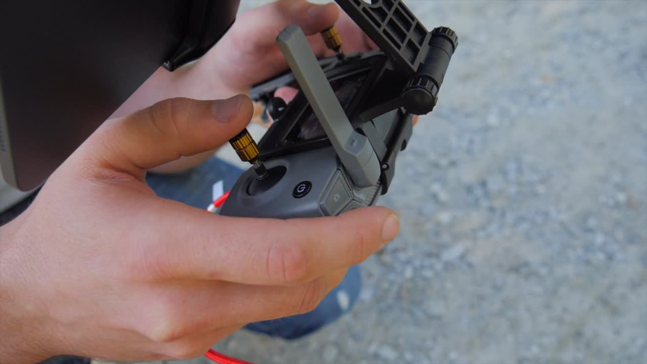 드론 조종사가 들고 있는 dji rc mavic 2 컨트롤러의 느린 움직임 클로즈업  ⁇