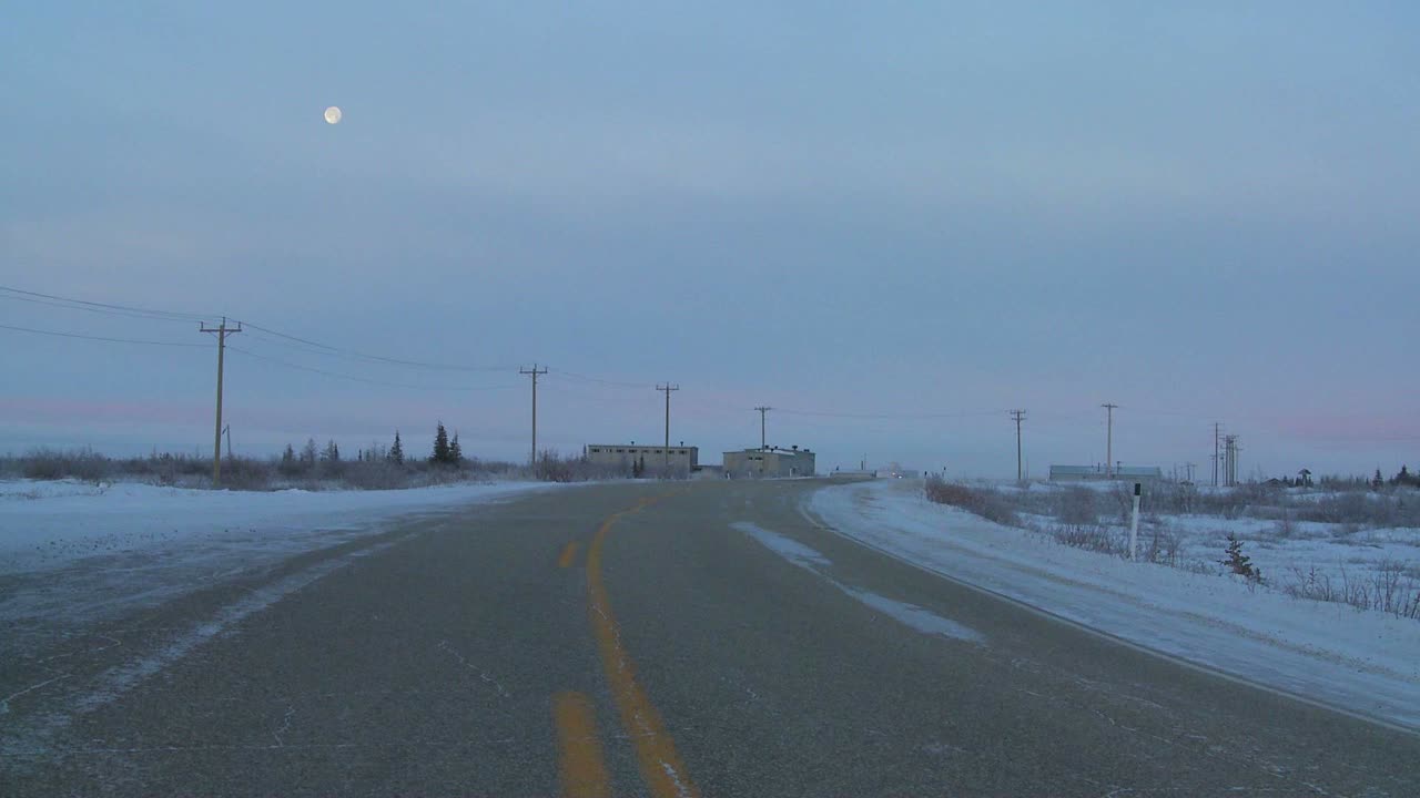 툰드라를 가로지르는 얼어붙은 고속도로 뒤로 달이 떠오른다