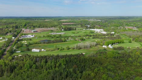 beautiful golf course and vast green forest in sunny canada, drone view