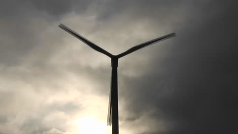 molino de viento retroiluminado genera energía eléctrica en una ladera en california