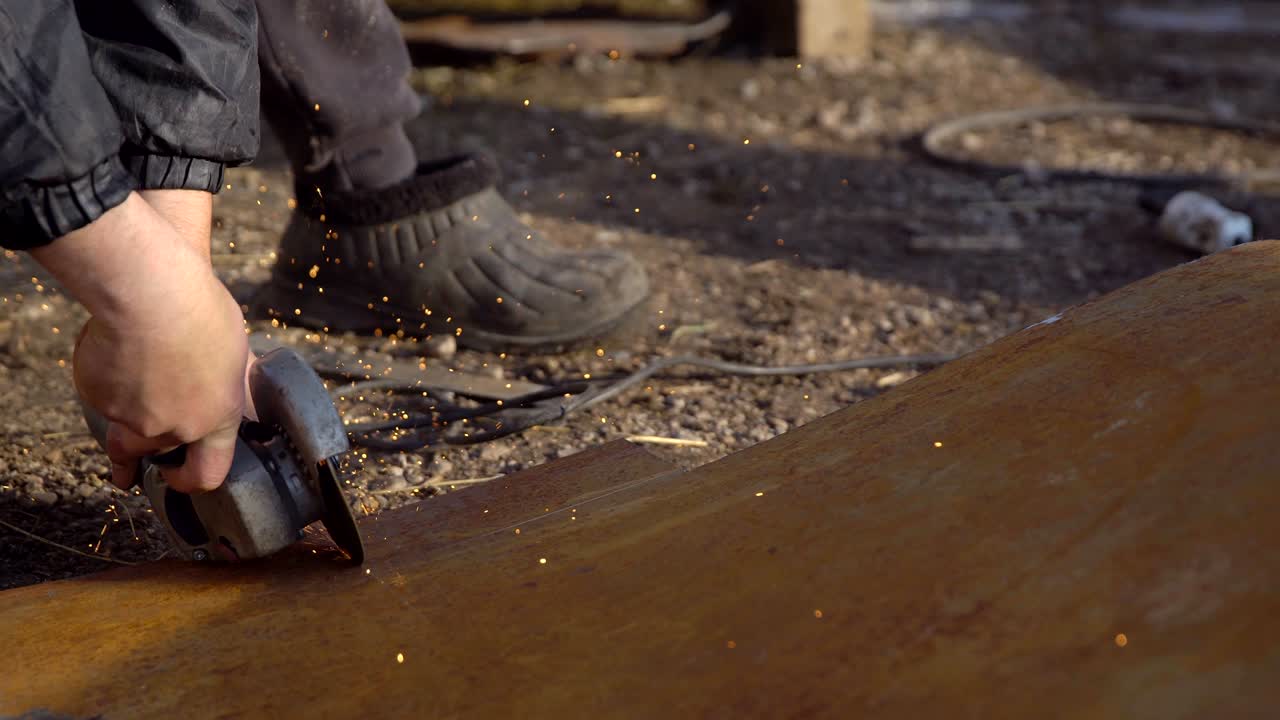 el hombre está cortando un pedazo de hierro con una sierra para el metal