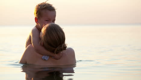 Madre-Amorosa-Abrazando-A-Su-Hijo-En-El-Mar.