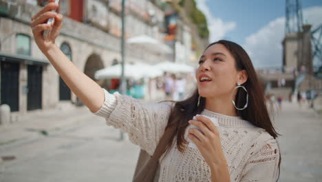 tourist woman making selfie with coffee on city view closeup. brunette posing