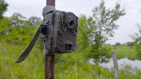 rising shot of a trail camera attached to a t post