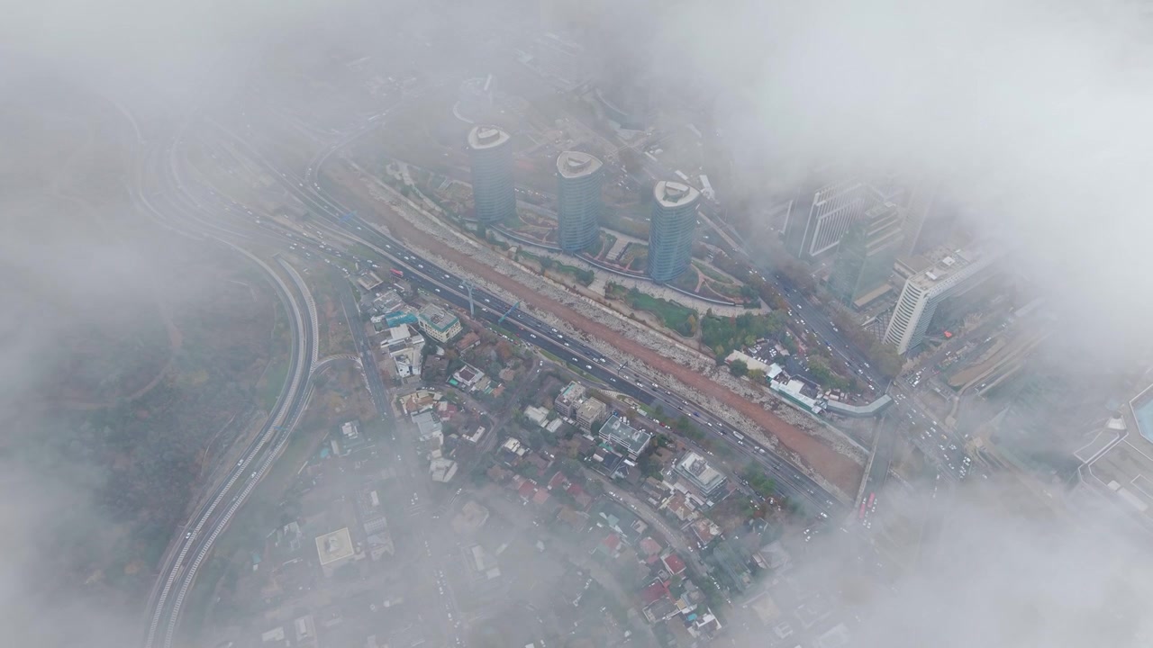 Aerial Flight Cityscape Through Clouds of Parque Titanium and Traffic Santiago de Chile city