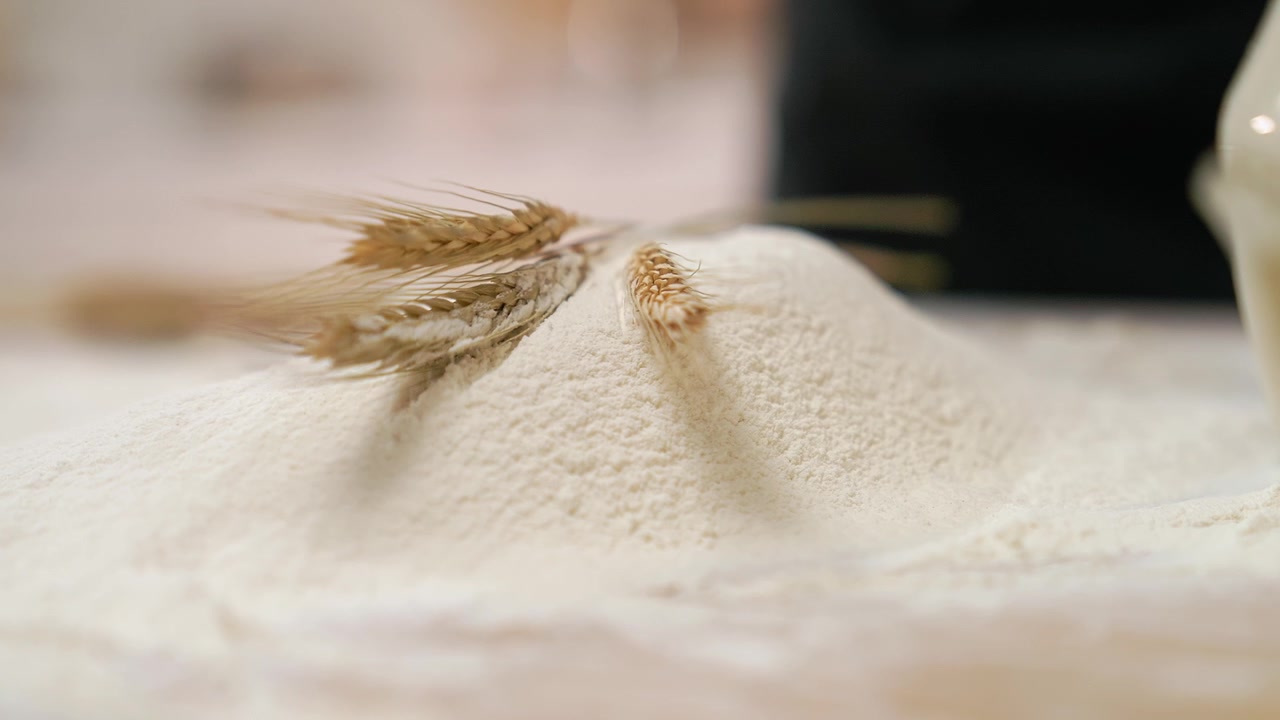 Spighe di grano dorate poste su un mucchio di farina