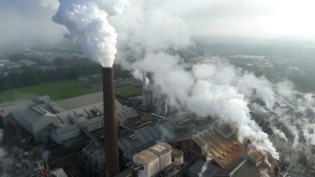 Prospettiva aerea industriale di una fabbrica di produzione di zucchero a Bury St Edmunds, Regno Unito, con macchinari attivi e ciminiere che emettono vapore.
