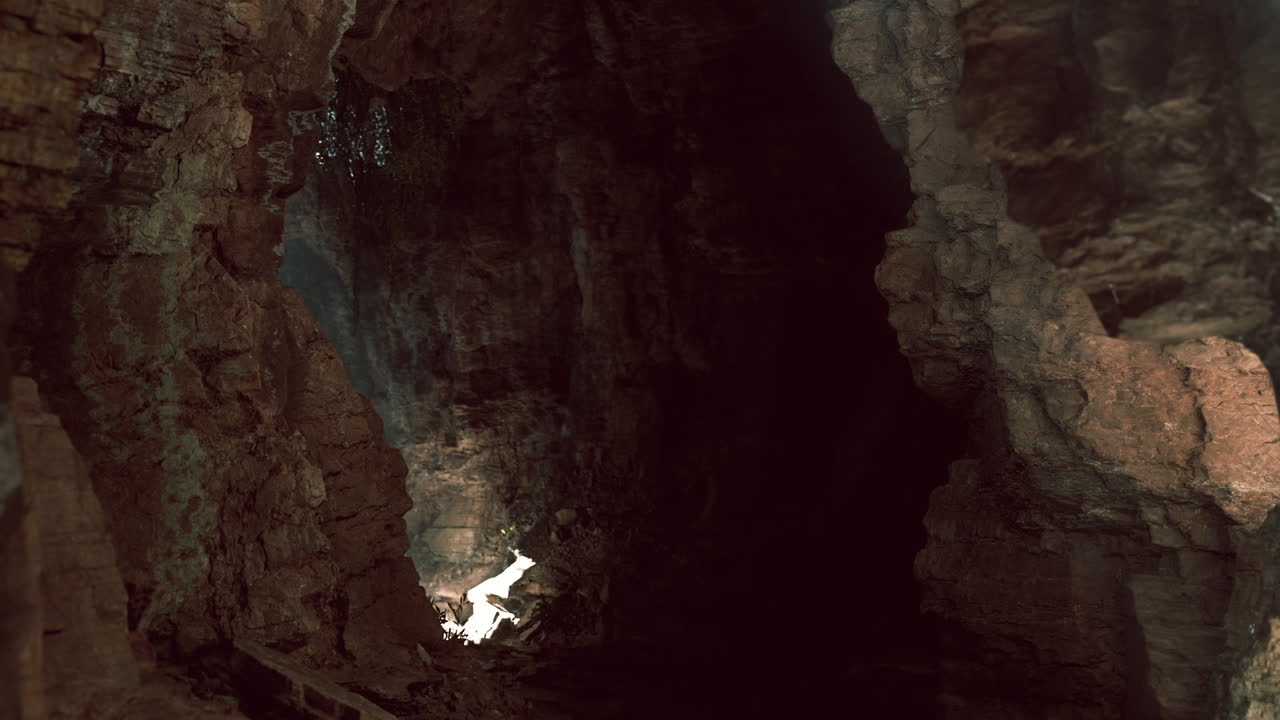 Esplorare una grotta oscura con formazioni rocciose suggestive e illuminazione delicata