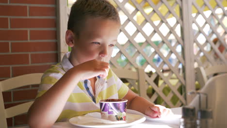 Niño-Comiendo-Helado-De-Chocolate-En-La-Cafetería