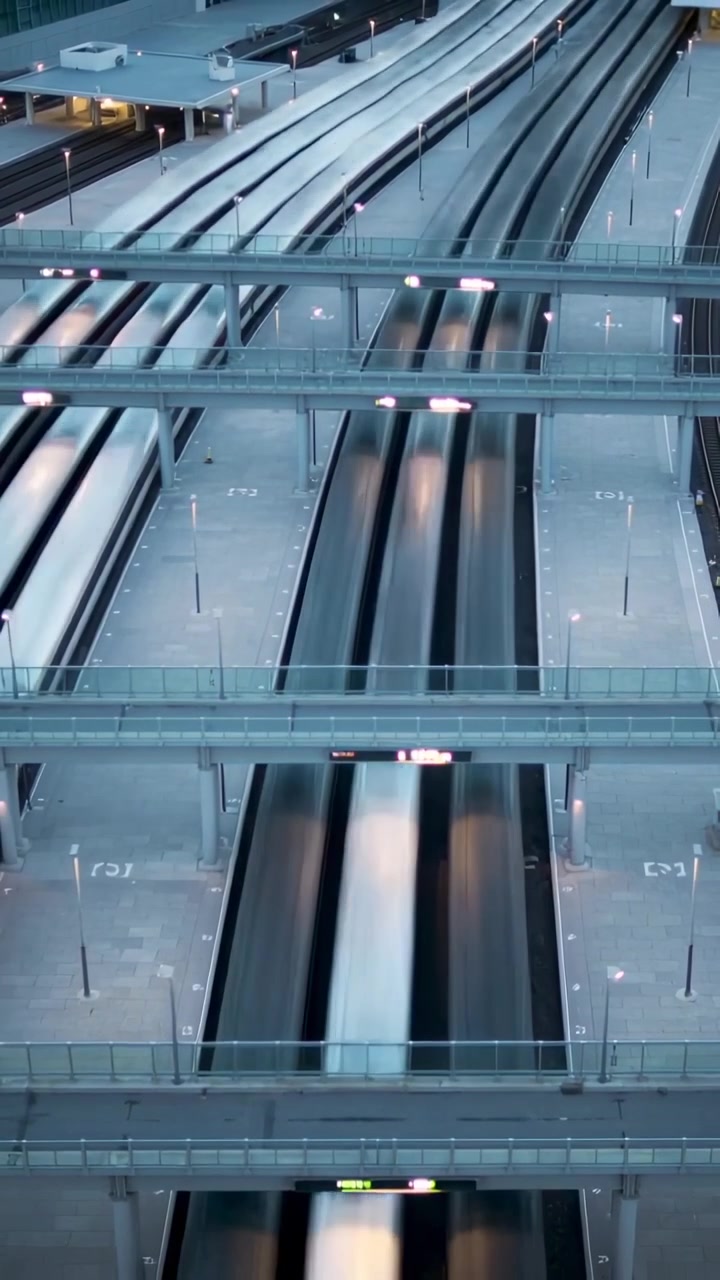 Vídeo vertical: Entrando em trens prateados movendo-se pelos trilhos da estação, para o próximo serviço